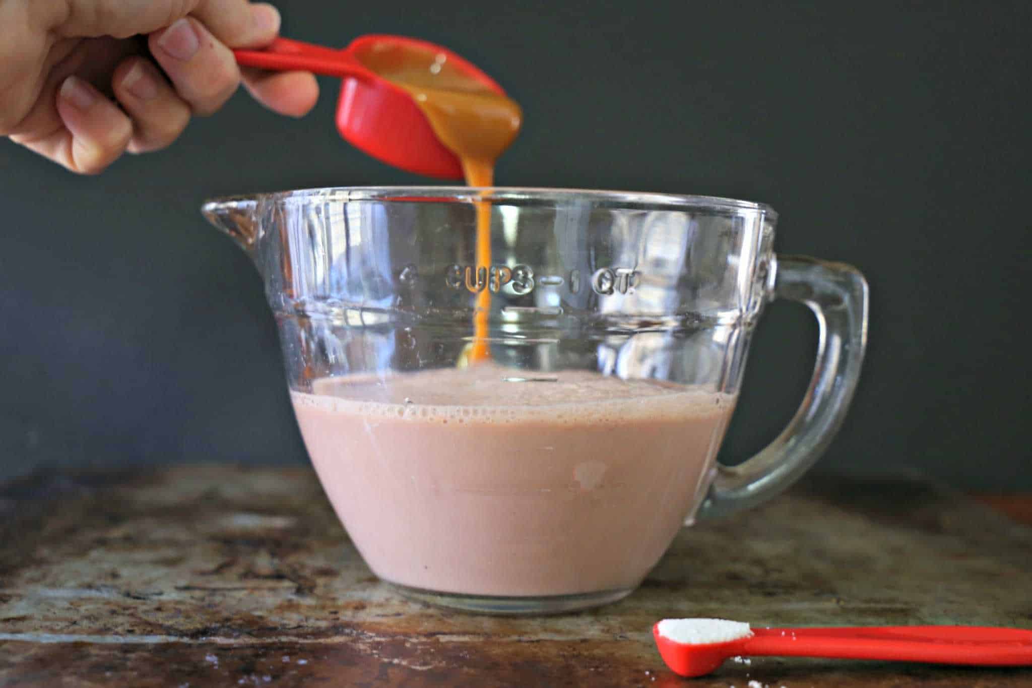 Salted Caramel Hot Chocolate - this recipe is super easy for making the BEST and easiest Salted Caramel Hot Chocolate. This foolproof recipe will change the way you make hot chocolate from now on. #TryTruMooHot #Recipe caramel being poured into chocolate milk
