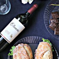beef sandwich with horseradish spread and a bottle of wine