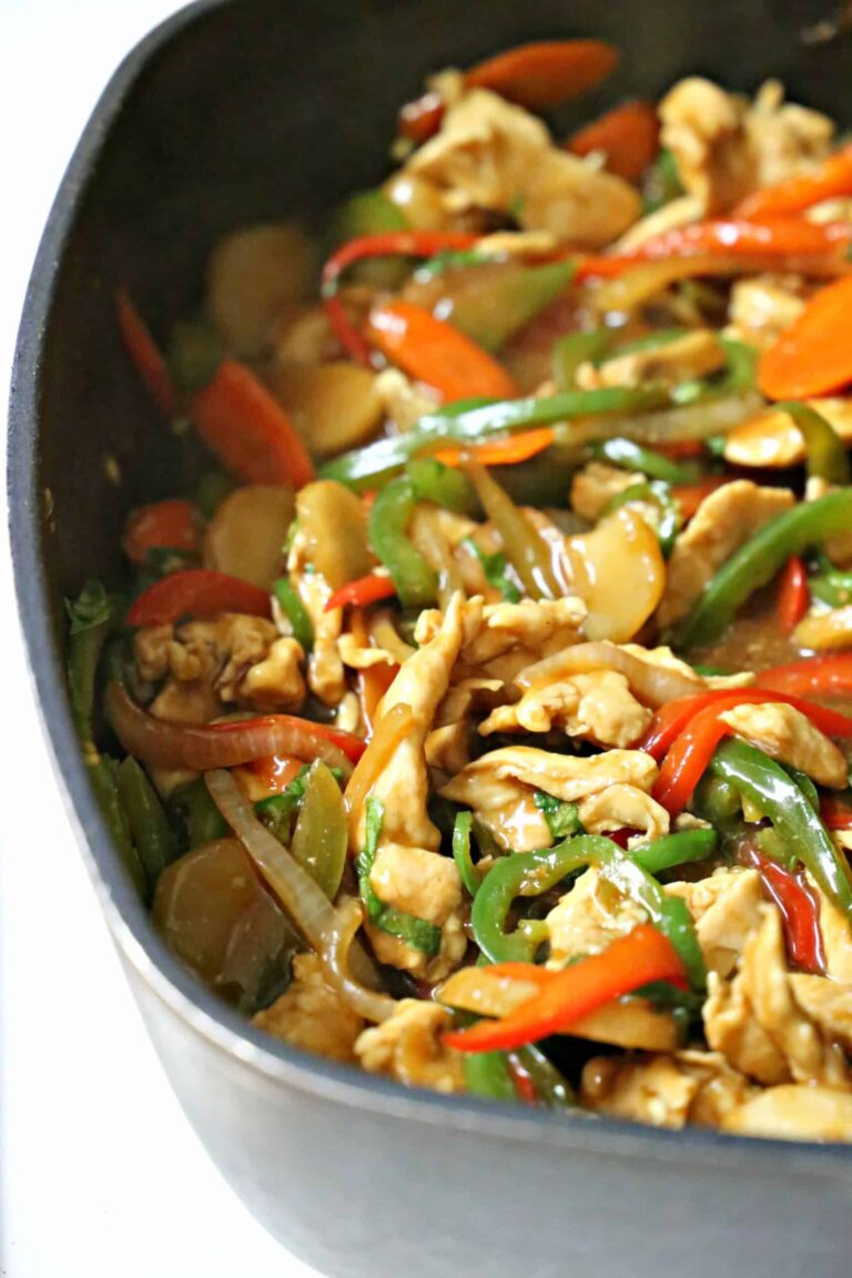 Chicken cooked in a skillet with bell peppers, mushrooms, and water chestnuts.