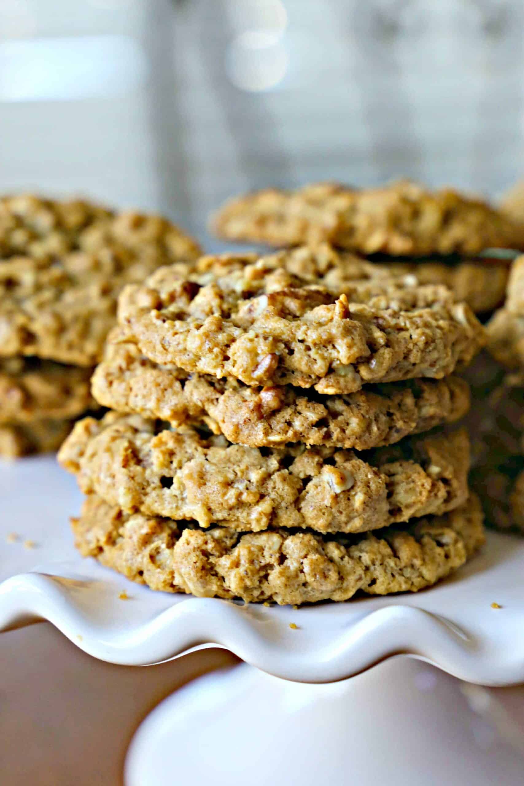 Stack of pecan cookies on a white pedestal.