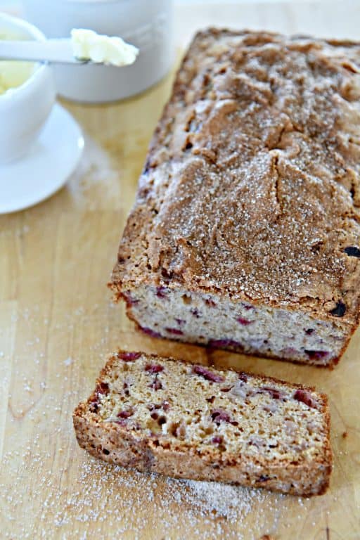 loaf of strawberry bread on a wooden cutting board