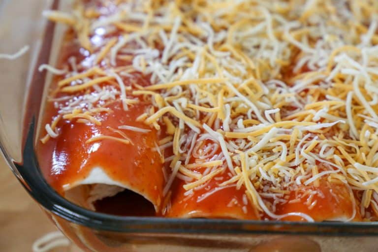 Top the enchiladas with cheese before placing them in the oven. cheese on top of enchiladas
