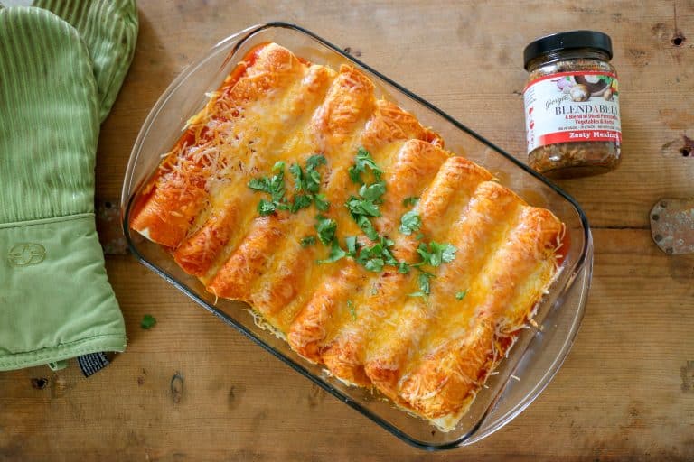 These delicious enchiladas will make your whole family happy. enchiladas on a board with a jar of BLENDABELLA