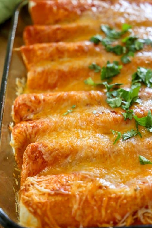 These Zesty Cheesy Enchiladas will be the star of your next TexMex dinner. red enchiladas in a pan topped with cilantro
