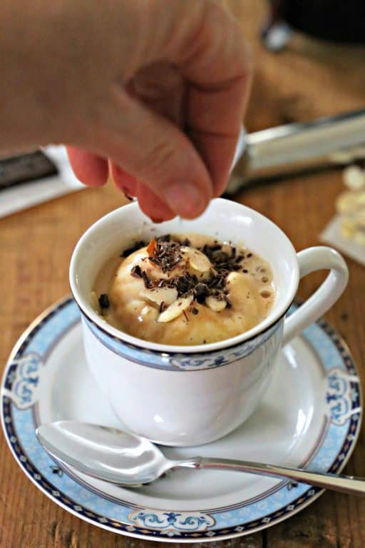 Easy Keto Affogato sprinkling chocolate and sliced almonds on top of ice cream