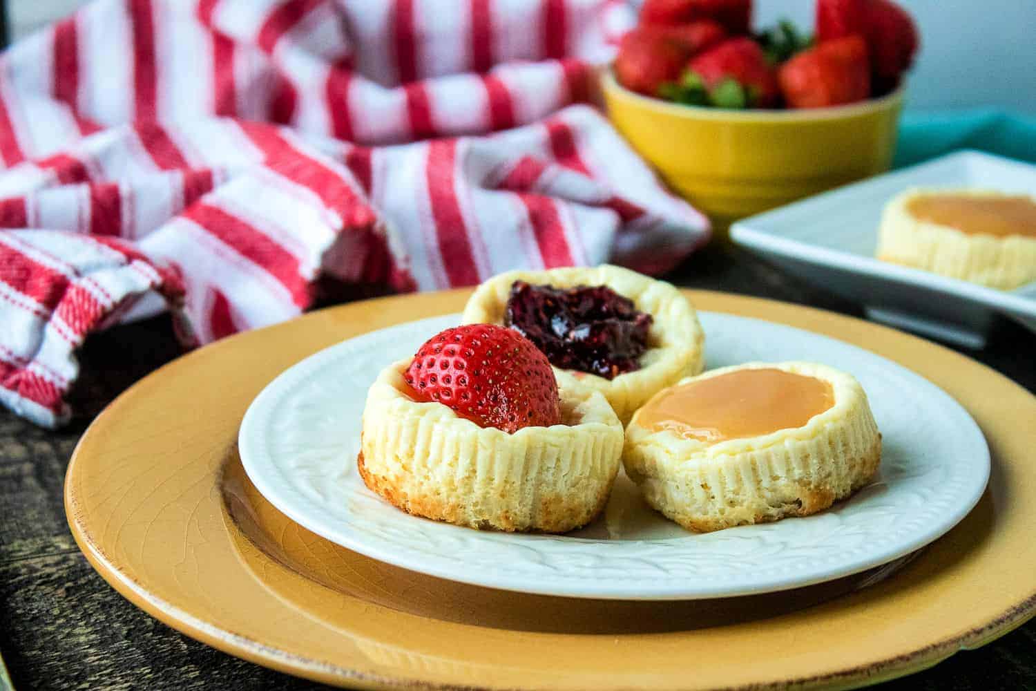 Miniature cheesecakes on a plate.