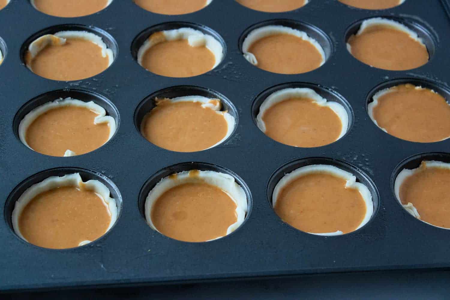 unbaked mini pumpkin pies in muffin pan