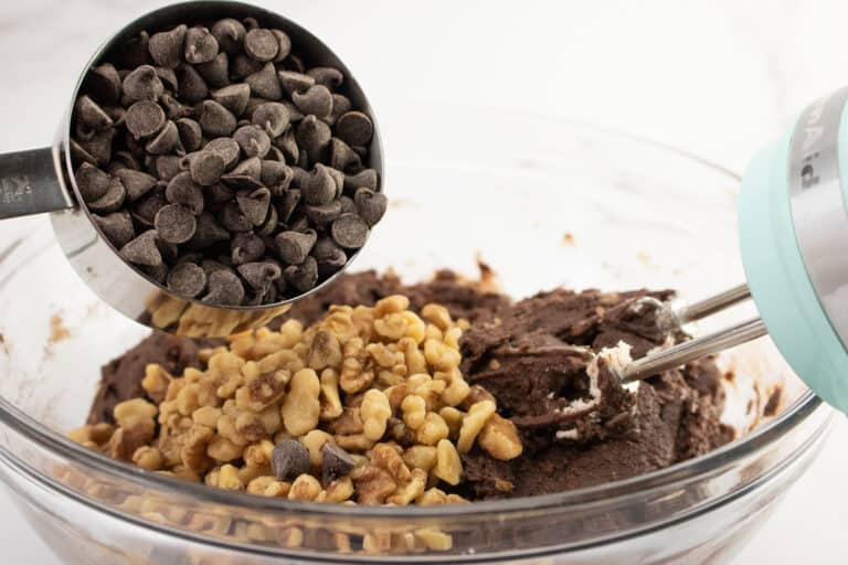 adding nuts and chocolate chips to brownie batter