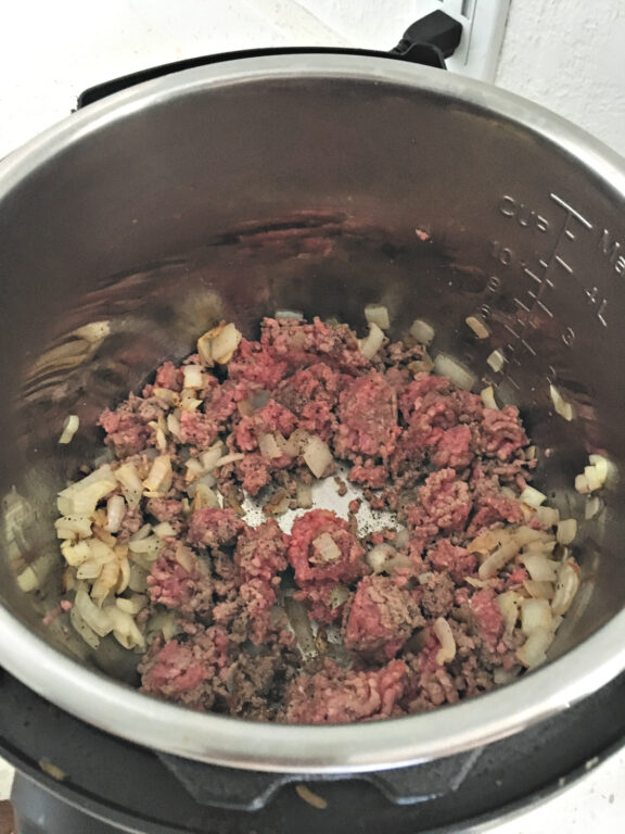 ground beef and onions in an Instant Pot