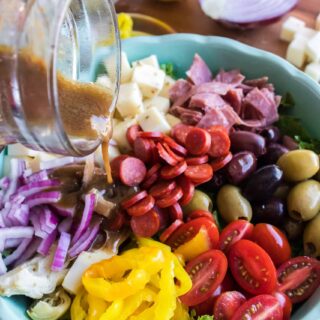 pouring salad dressing on to salad
