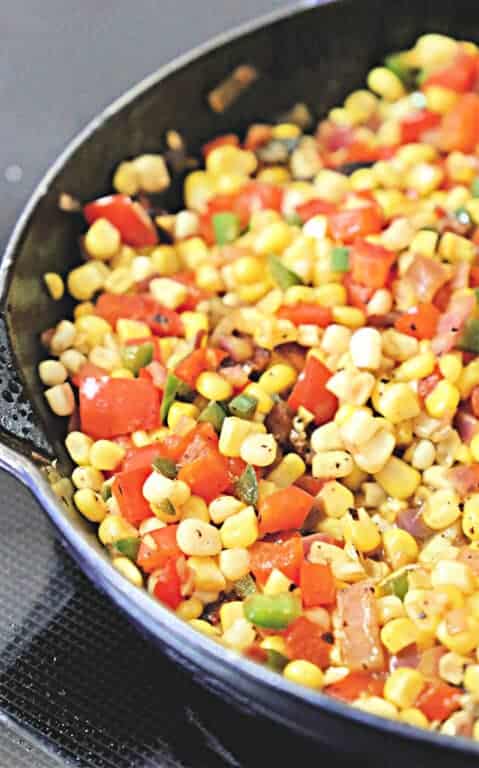 fried corn with bacon and fresh jalapeños in a skillet