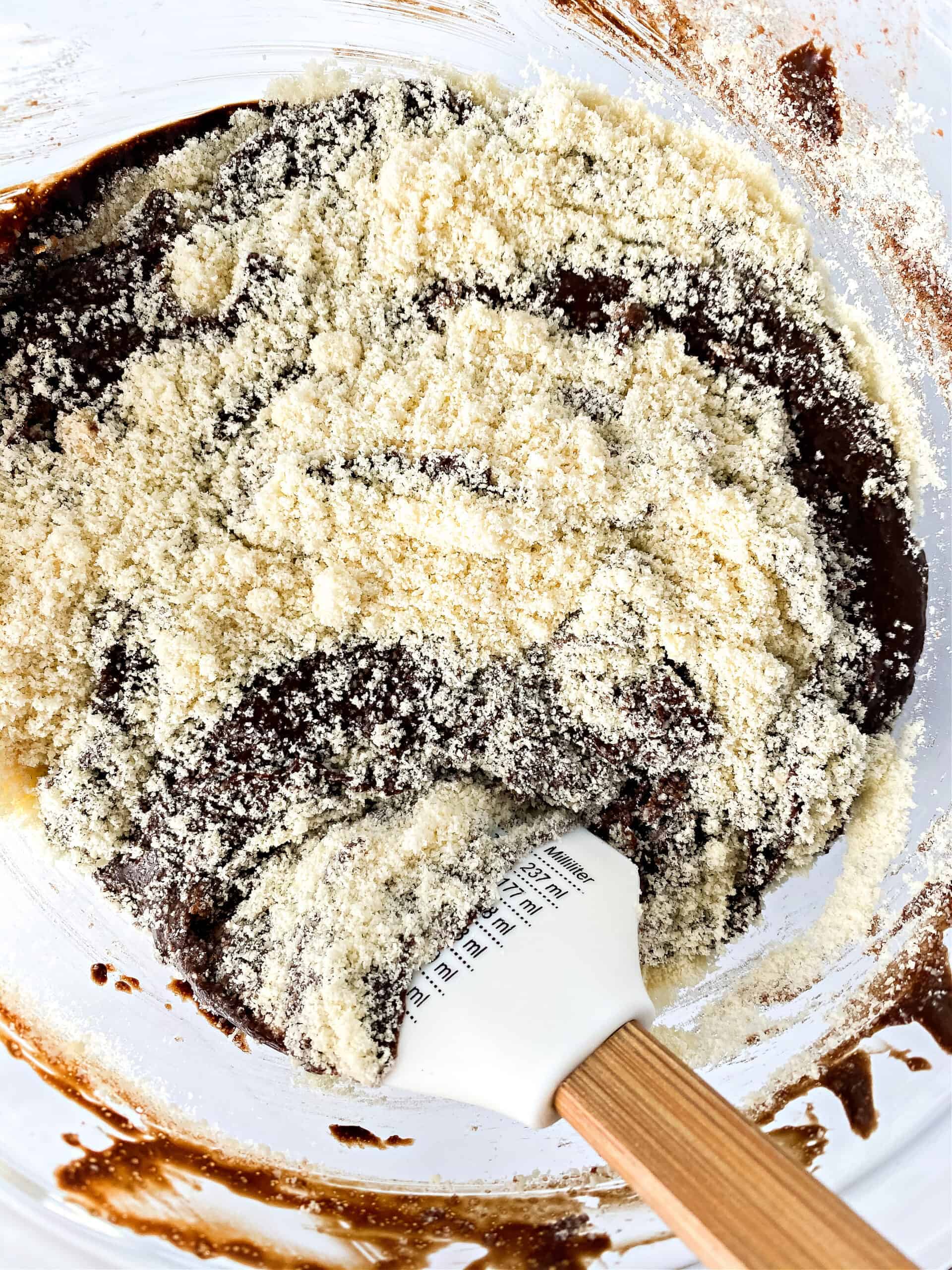 Mixing almond flour into brownie batter mixture.