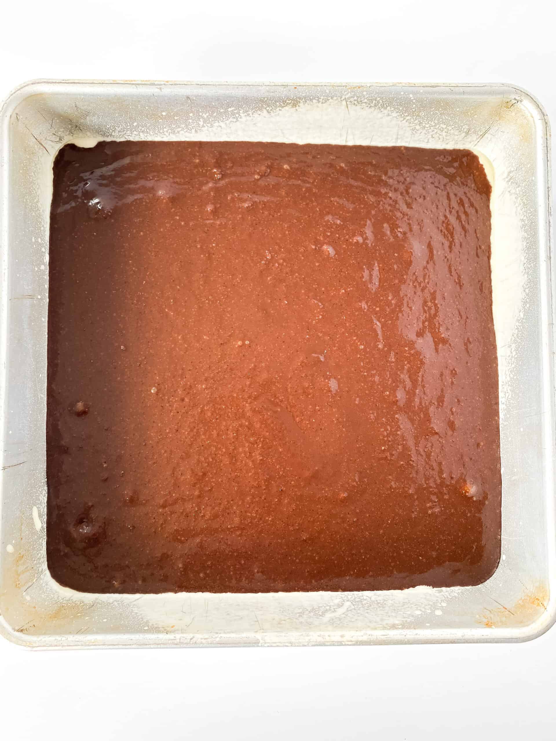 Unbaked brownies in an 8x8 baking dish.