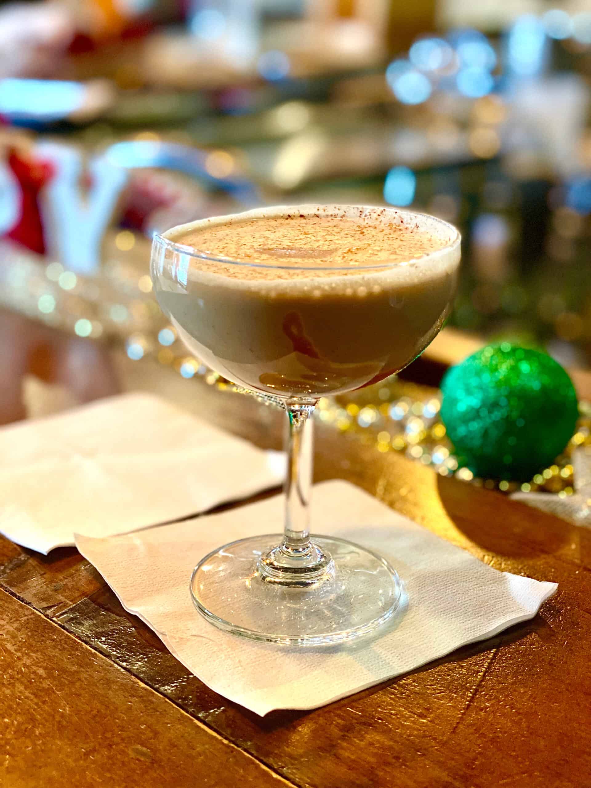 Holiday cocktail and a green Christmas ornament.