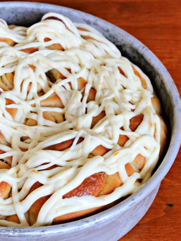orange rolls in a pan with icing