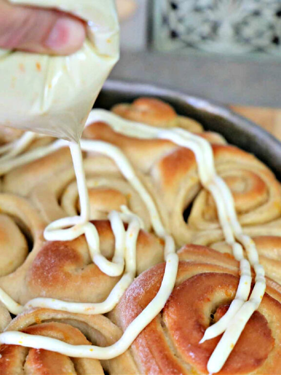 squeezing icing on rolls