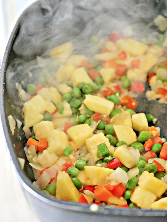 pineapple and vegetables being stir-fried