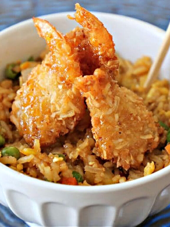 bowl of tropical fried rice topped with coconut shrimp