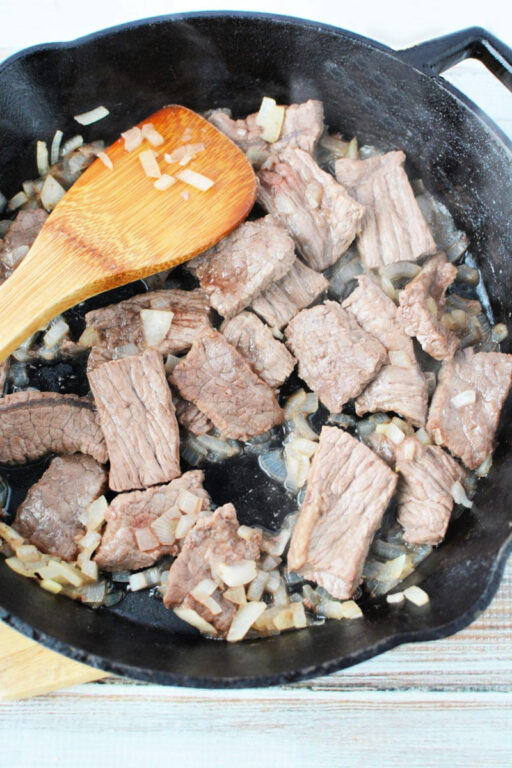 Easy Beef Stroganoff with Mushroom is quick 30 minute and under meal with big homemade flavors #beef #easydinner #recipe cooked beef and onion in a skillet