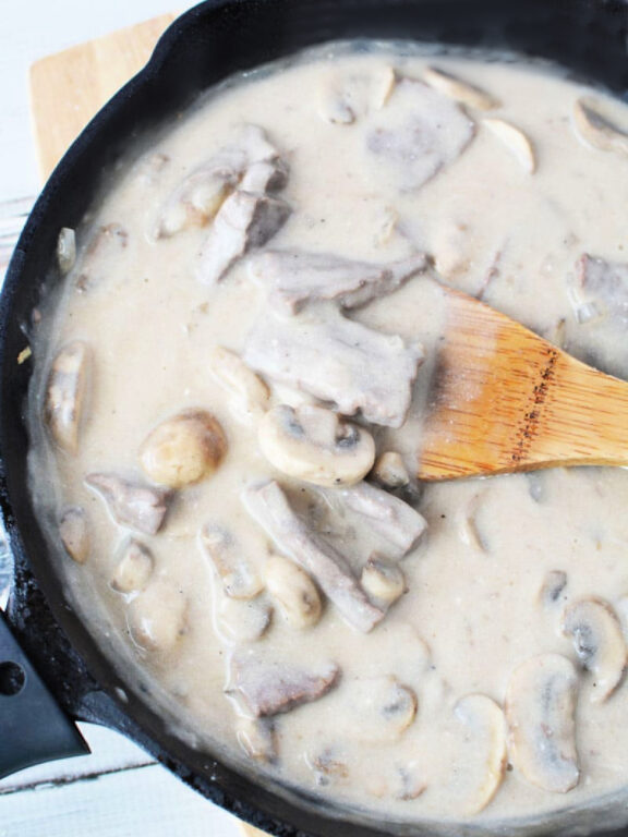 Easy Beef Stroganoff with Mushroom is quick 30 minute and under meal with big homemade flavors #beef #easydinner #recipe stirring sour cream into stroganoff