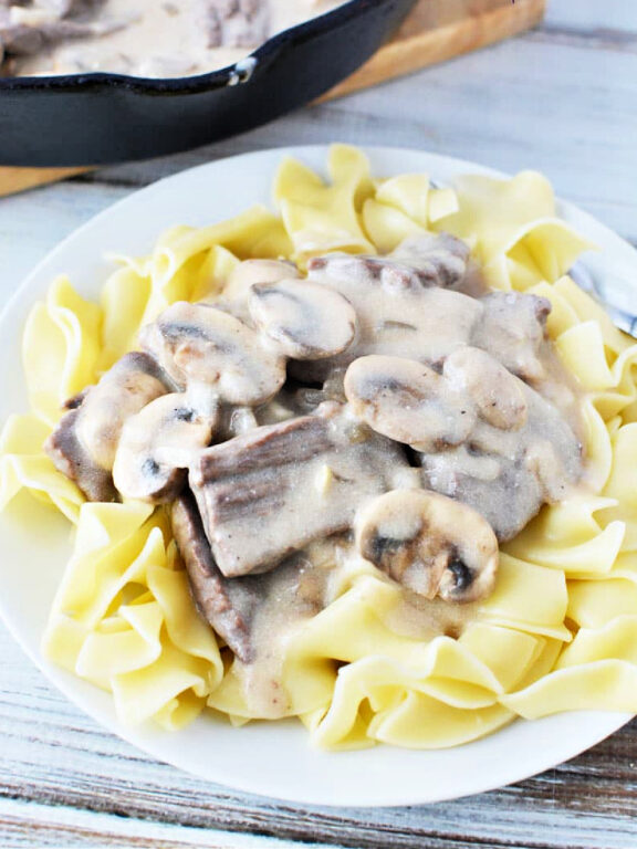 Easy Beef Stroganoff with Mushroom is quick 30 minute and under meal with big homemade flavors #beef #easydinner #recipe plate of beef stroganoff on top of noodles