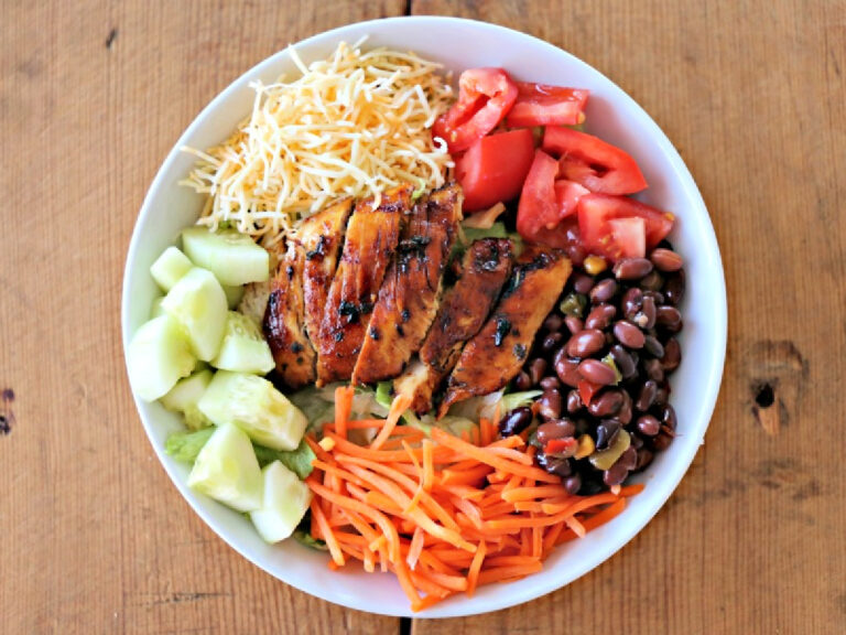 bowl of salad with chicken, carrots, cheese, and beans