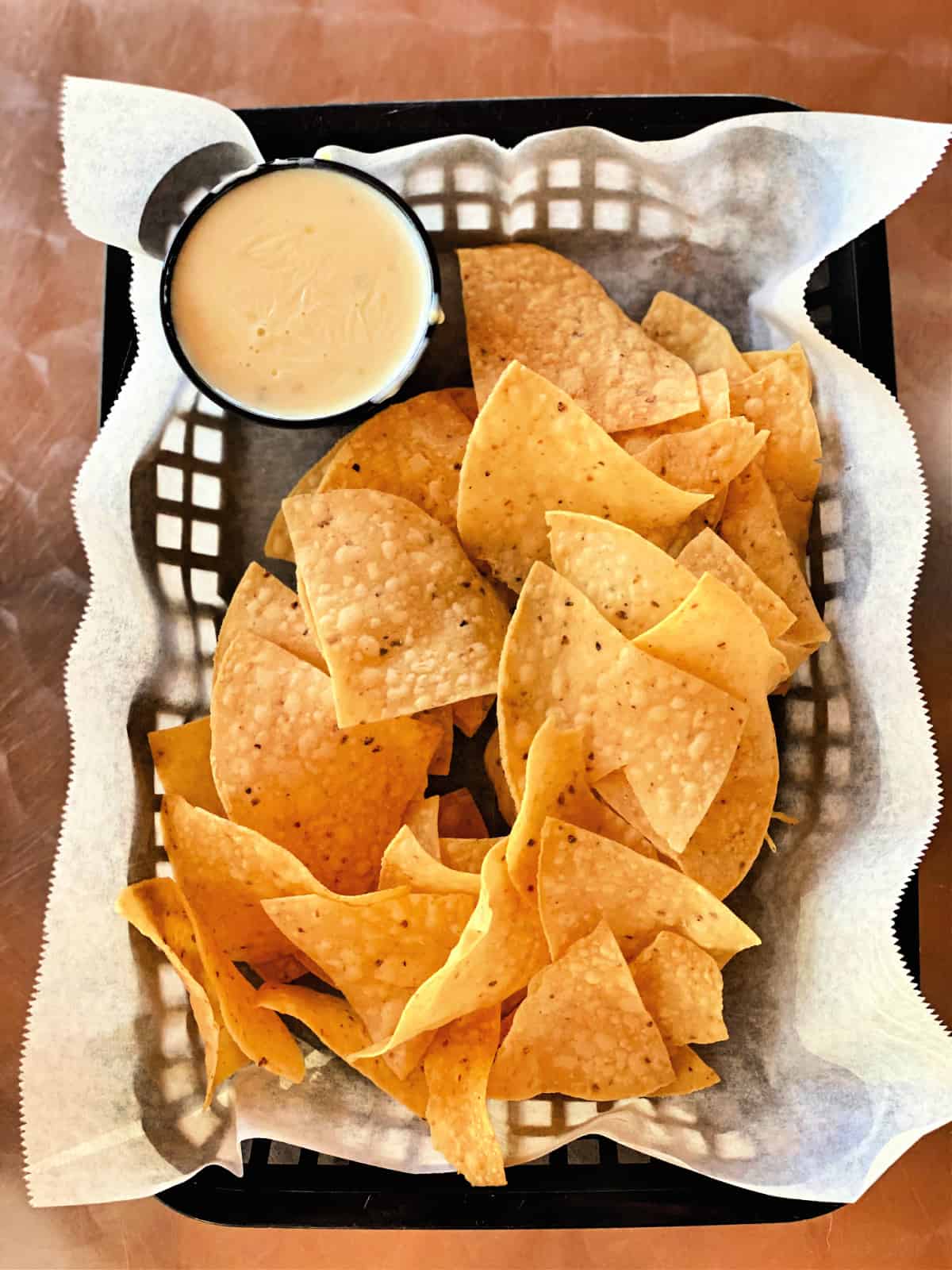 Chips and cheese dip in a basket.