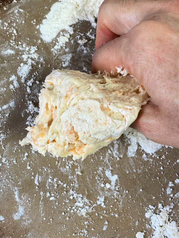 pinching off a portion of biscuit dough