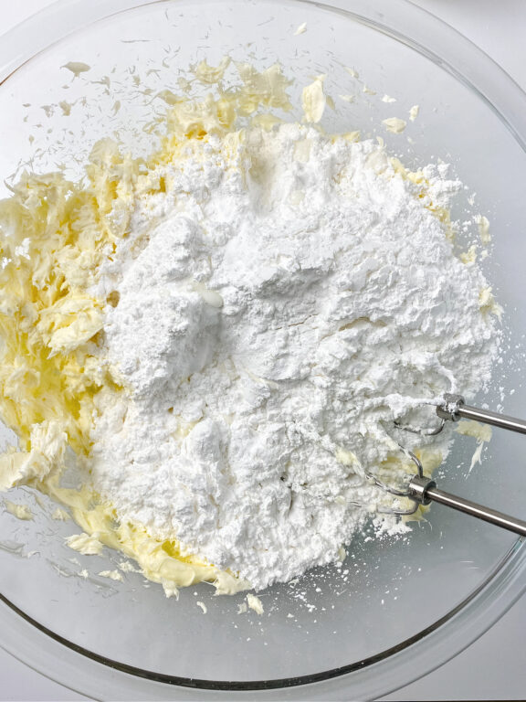 powdered sugar and creamed butter in a bowl