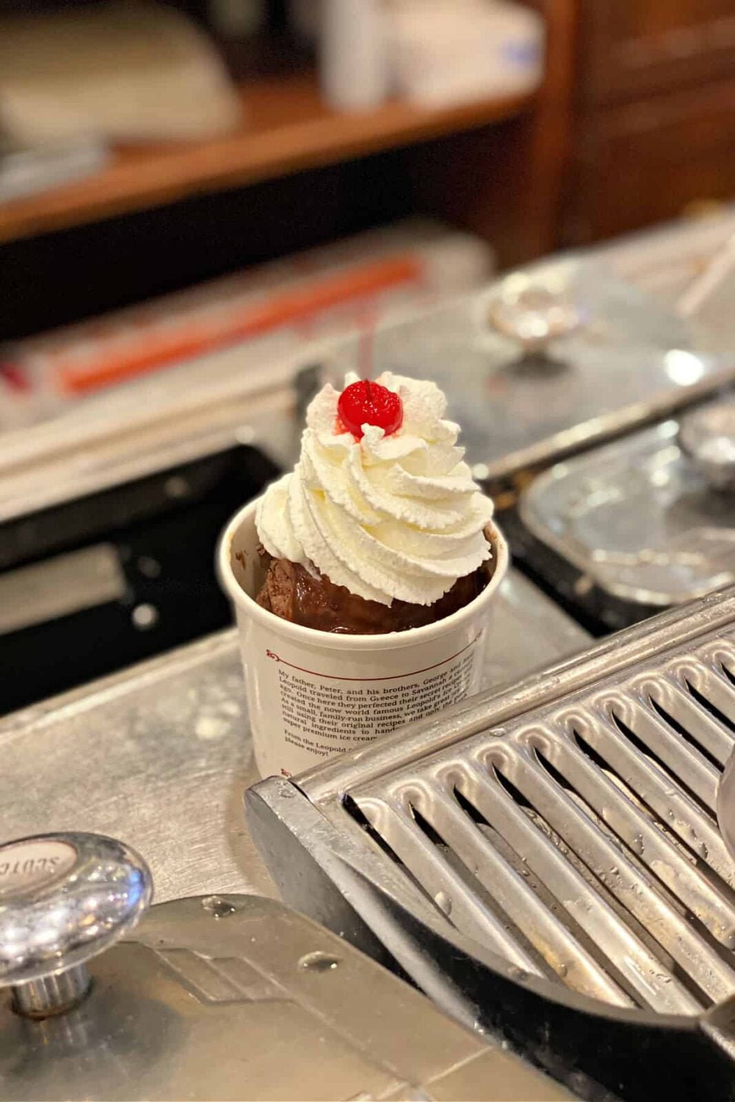 Brownie with whipped cream and cherry on top.