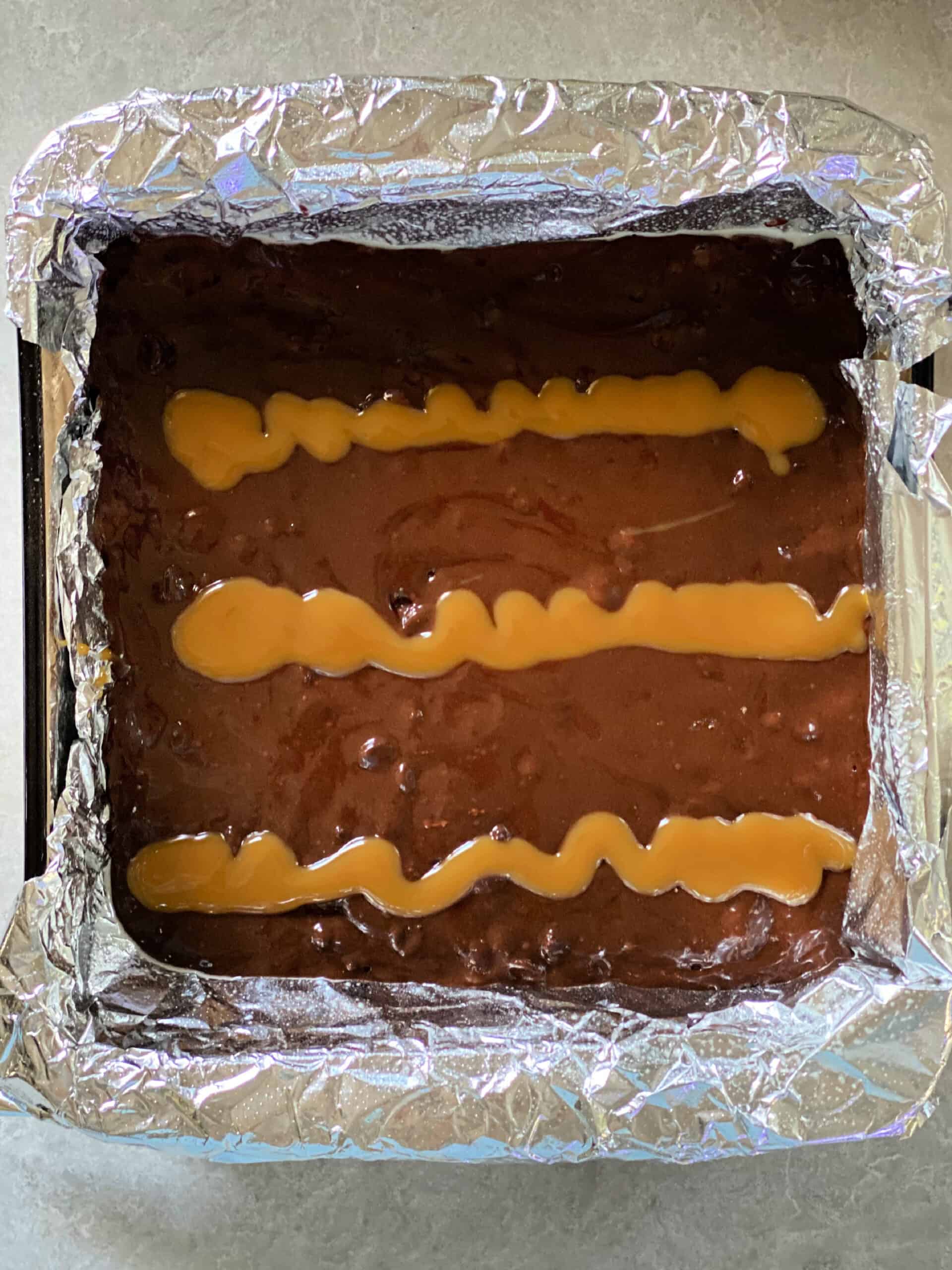 Caramel sauce on brownie batter.