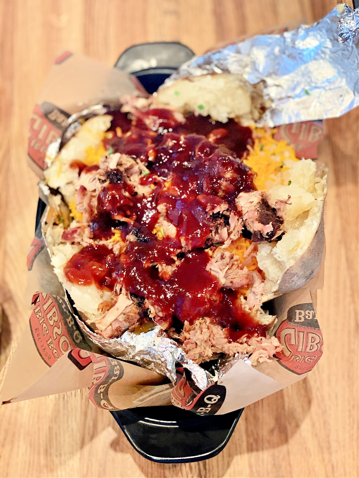 Large BBQ baked potatoes drizzled with BBQ sauce.