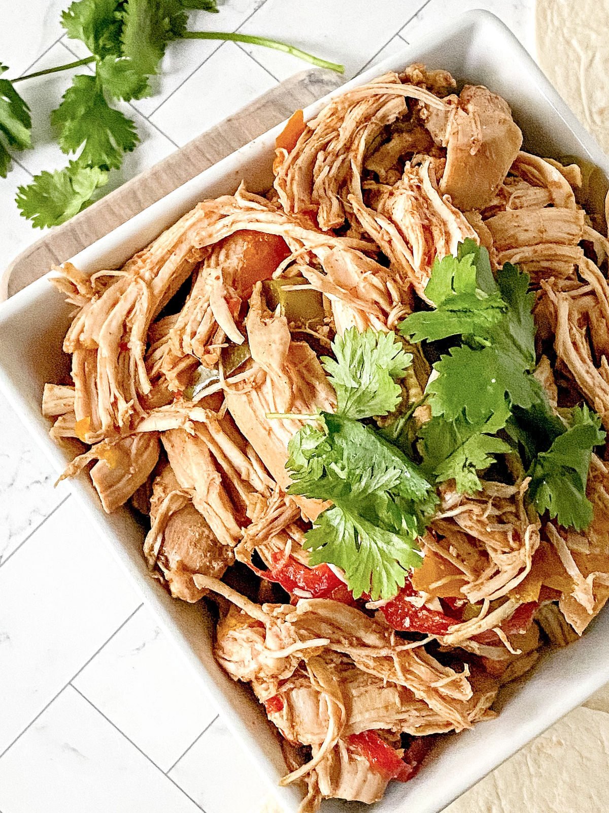Bowl of shredded chicken seasoned with fajita seasonings.