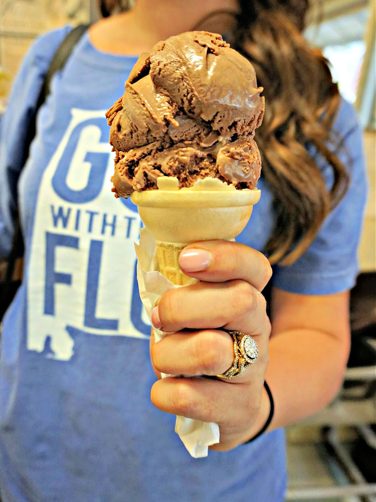 Where To Dine In the Shoals Lady holding two scoops of chocolate ice cream in an ice cream cone.