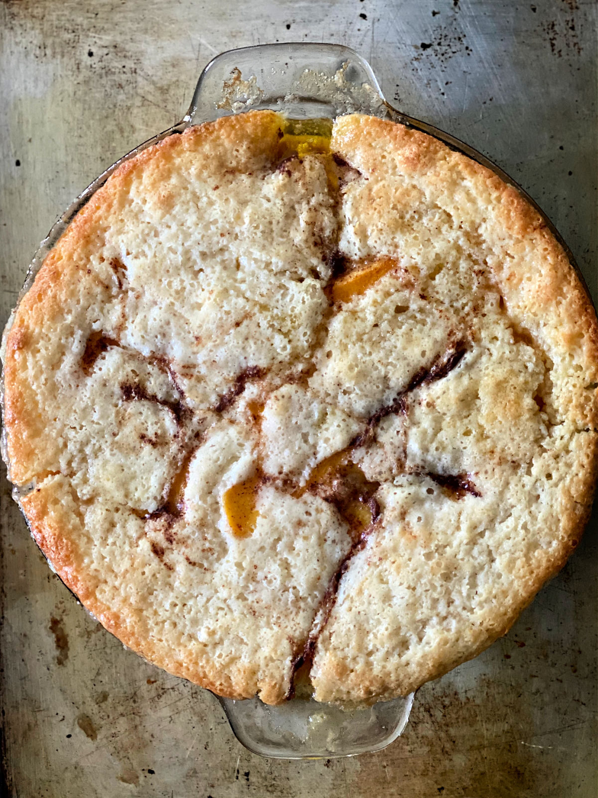 Peach cobbler in a round pie plate.