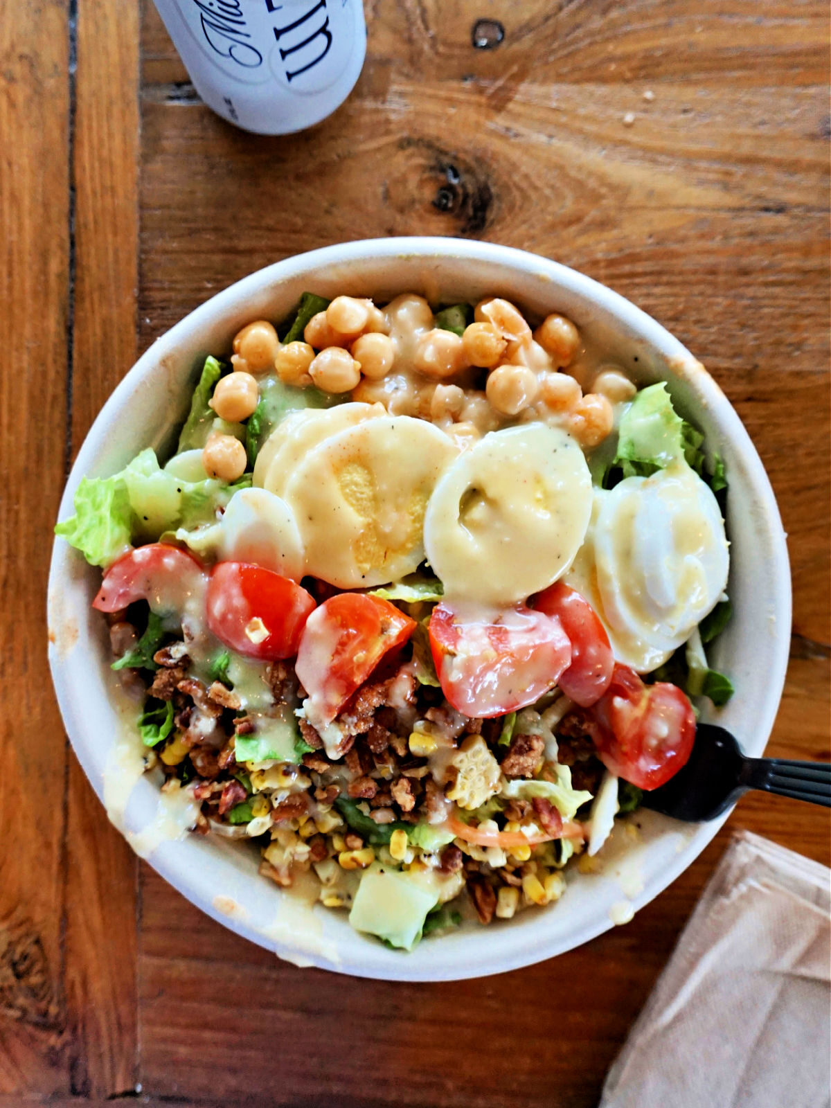 Bowl of grains, chick peas, tomatoes, cucumbers, lettuce, and hard boiled eggs.
