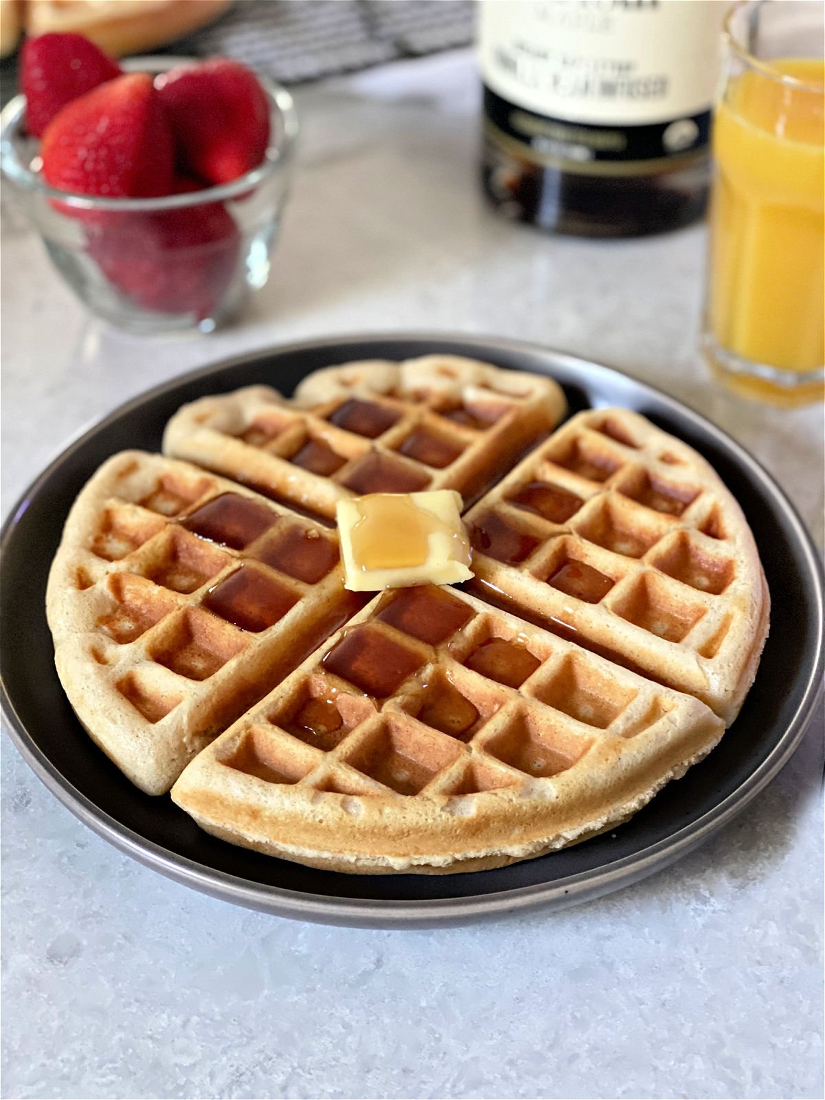 Fresh baked waffle with butter and syrup.