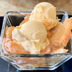 Bowl of peach cobbler and ice cream.