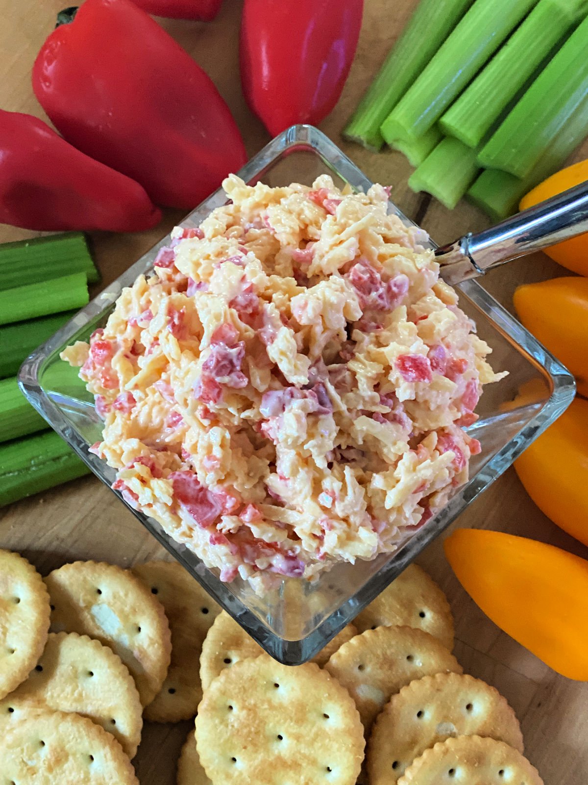 Village Tavern's Pimento Cheese Homemade pimento cheese with celery, peppers, and crackers on a board.