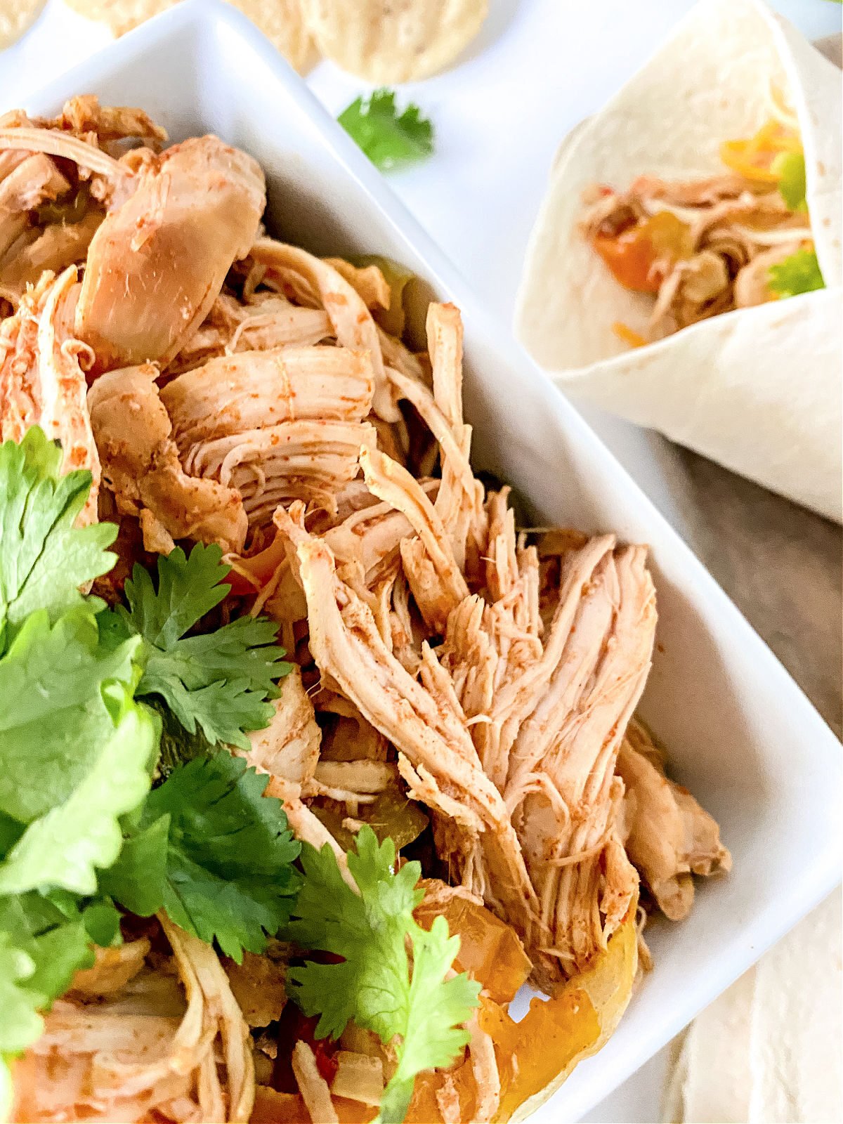 Bowl of chicken fajita meat and wrapped chicken fajita.