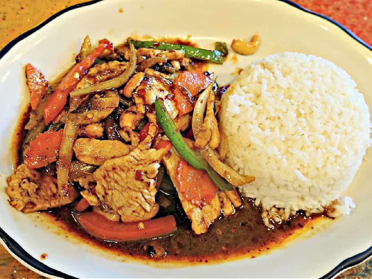 Spicy chicken with peppers, onions, and carrots with a side of white rice.