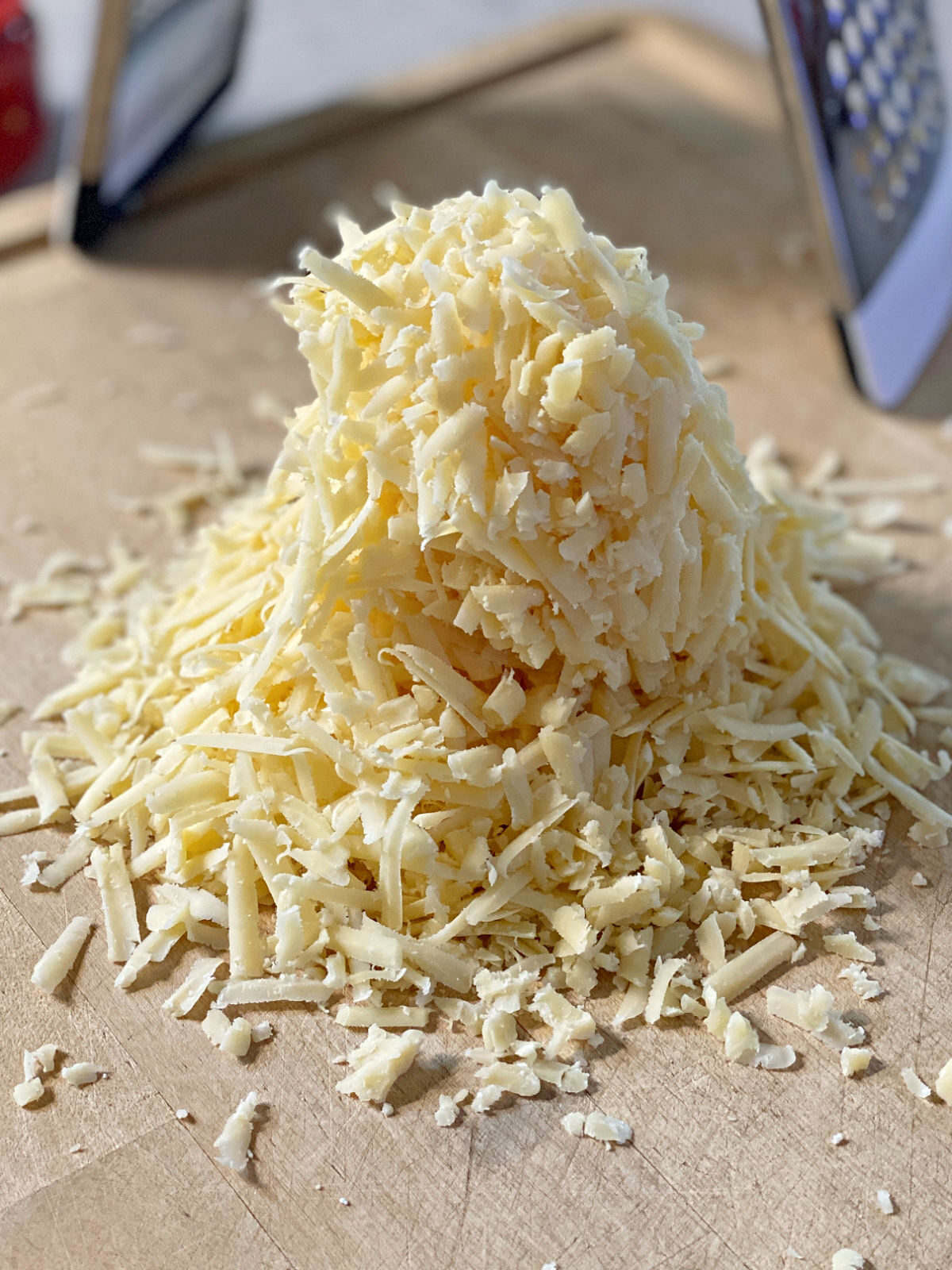 Village Tavern's Pimento Cheese Freshly shredded cheese on a cutting board.