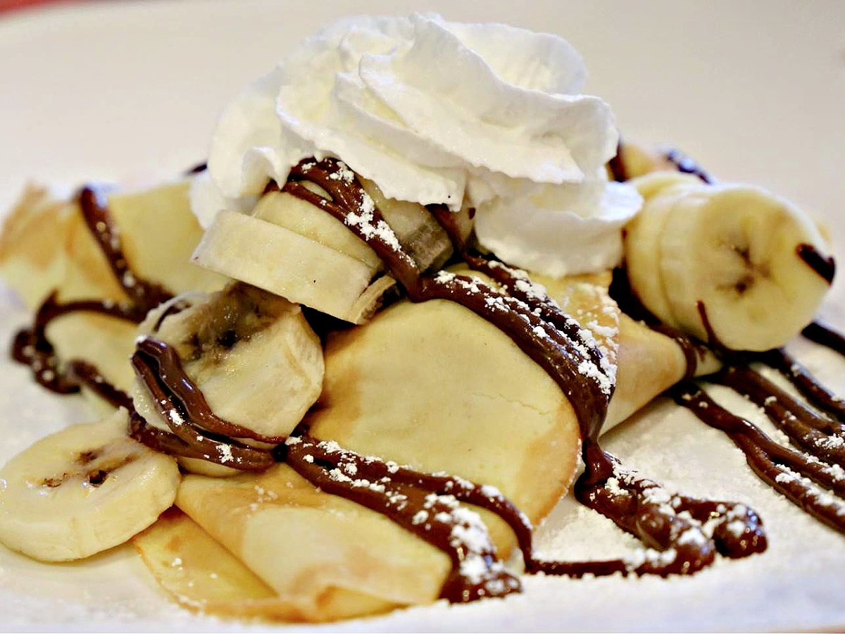 Where To Eat in Pittsburgh Plate of banana crepes drizzled with Nutella and topped with whipped cream.
