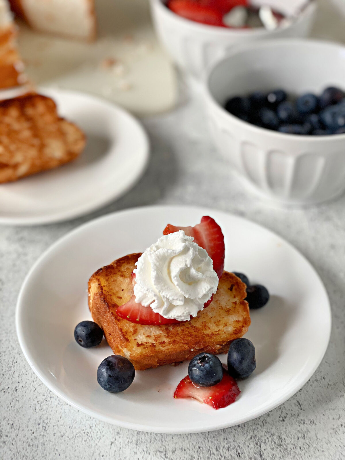 Toasted angel food cake with berries and whipped cream.
