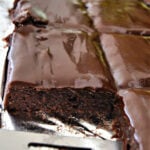 Sliced chocolate brownie cake and a metal spatula.