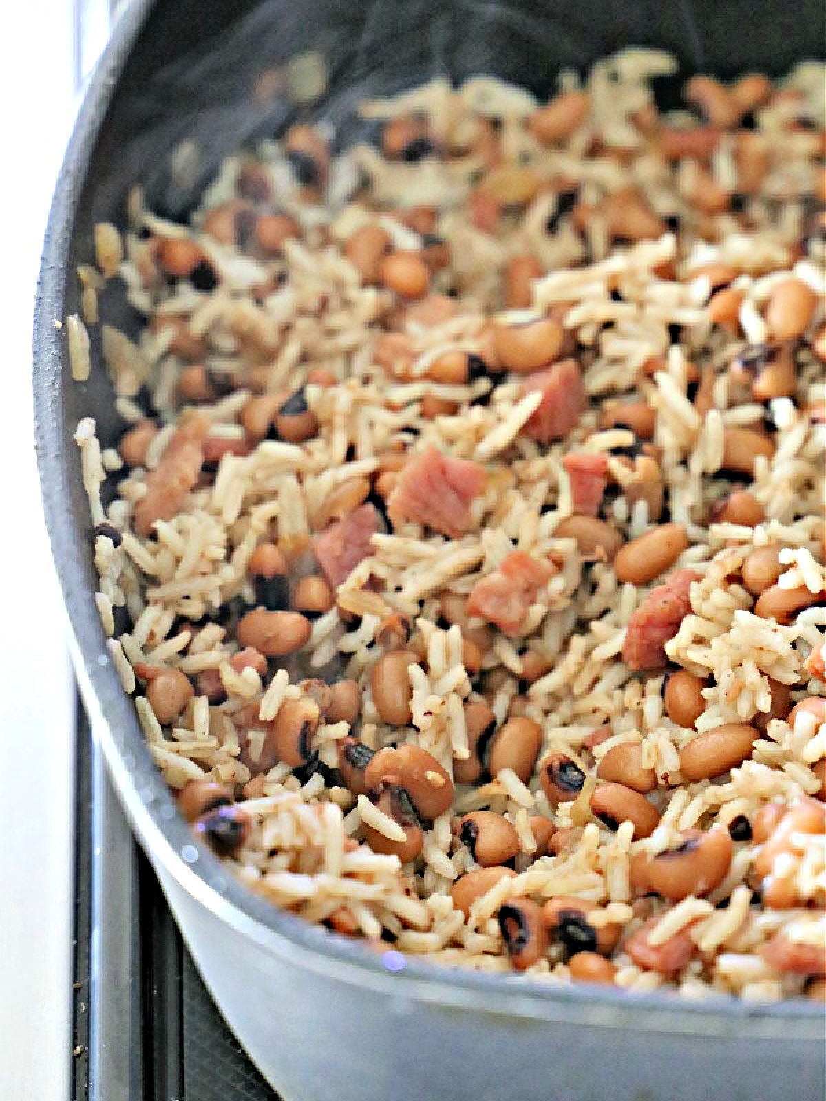 Gray non-stick skillet with rice and black-eyed peas.