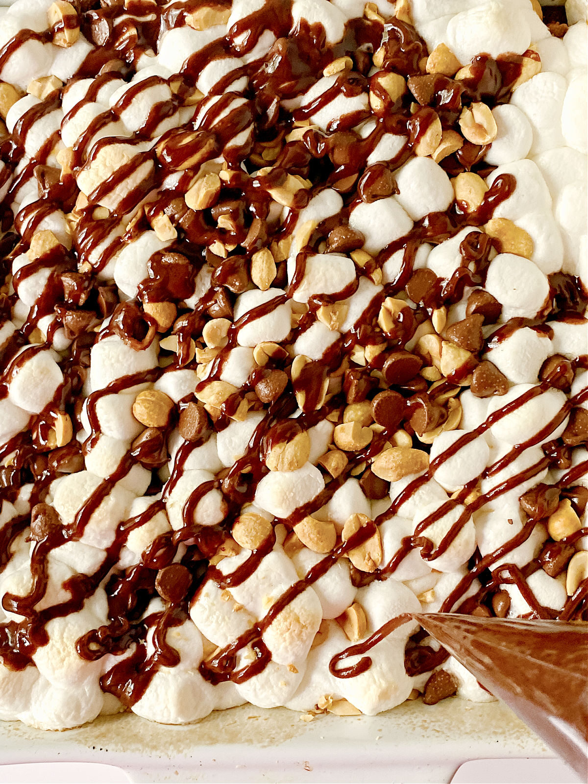 Drizzling chocolate on top of Rocky Road Brownies.