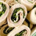 Sliced pinwheel sandwiches in a green container.