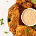 Plate of fried chicken fingers and dipping sauce.