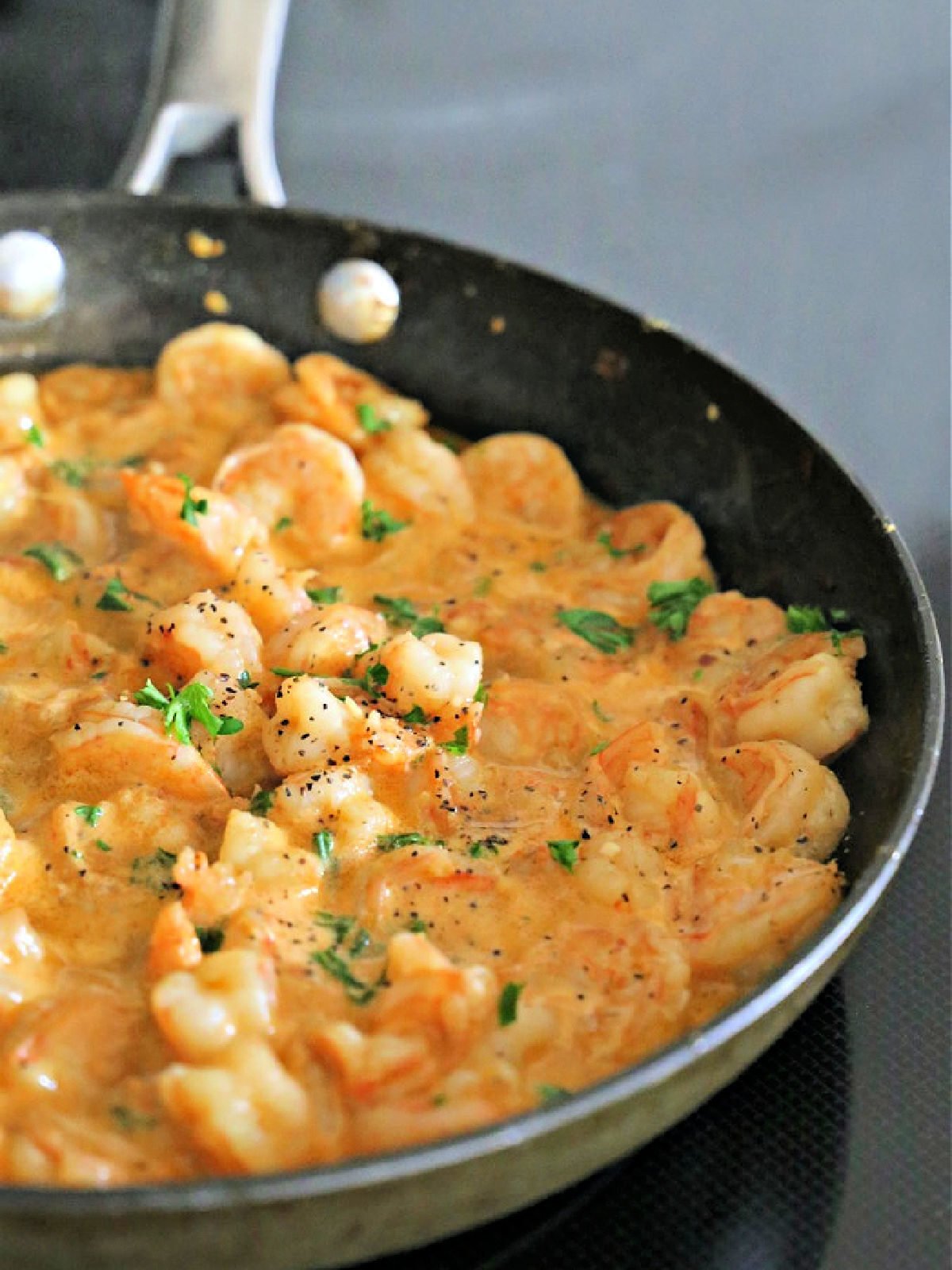 Texas Coast Shrimp Scampi Non-stick skillet with shrimp scampi garnished with parsley.